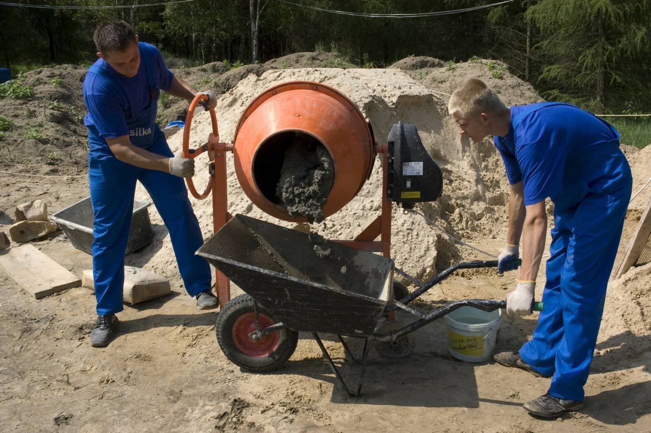 Budowa domu, betoniarka i robotnicy