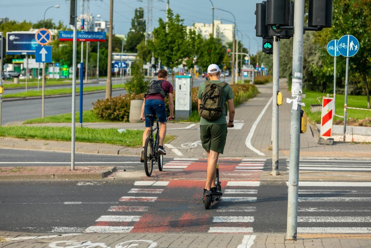 Elektryczna hulajnoga i rower przejeżdżające po przejściu dla pieszych