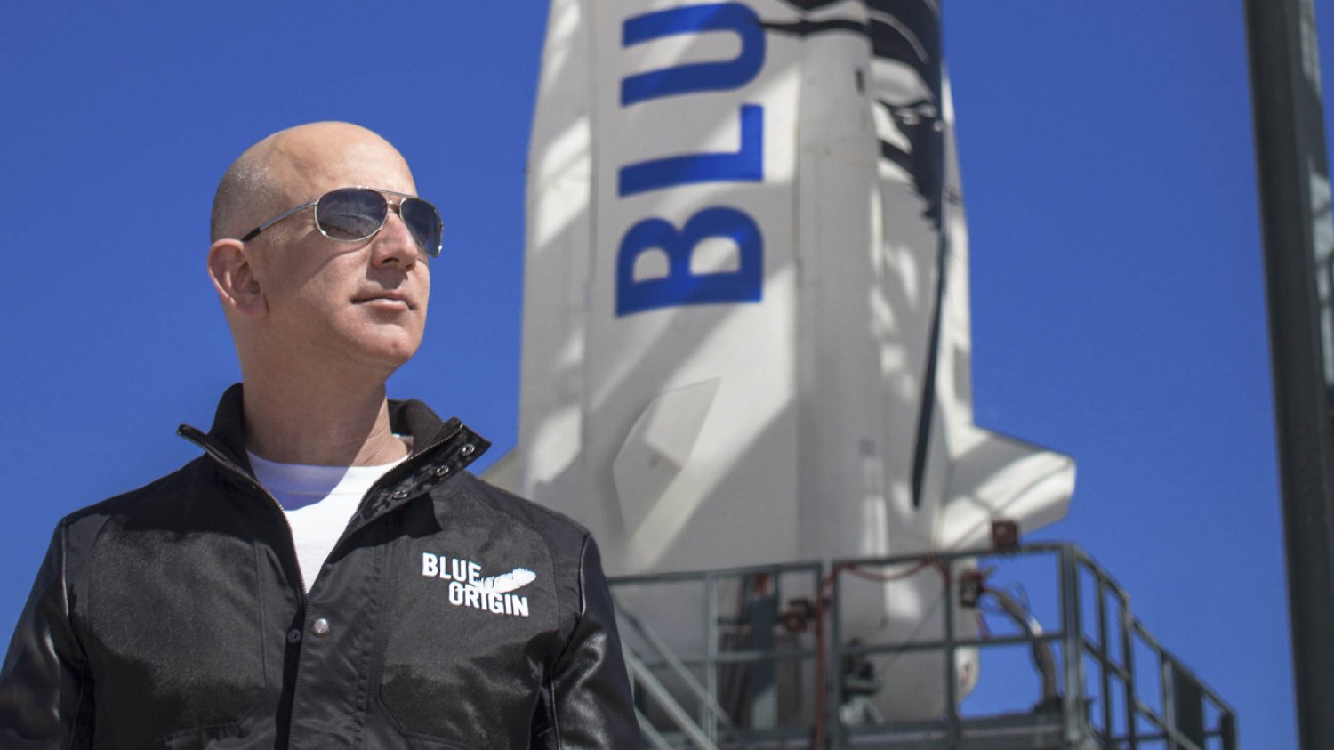 Jeff Bezos w kurtce z napisem "Blue Origin"