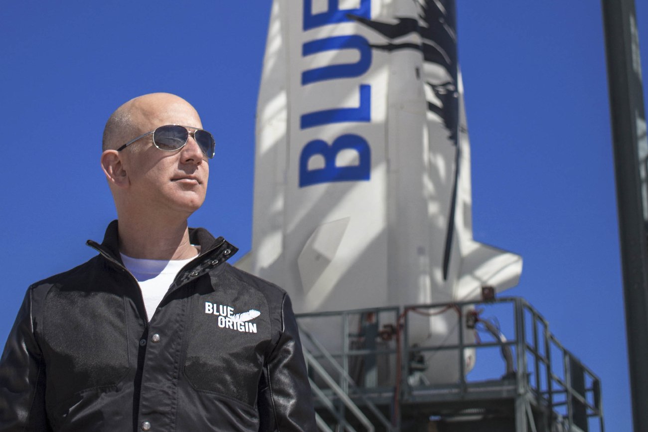 Jeff Bezos w kurtce z napisem "Blue Origin"