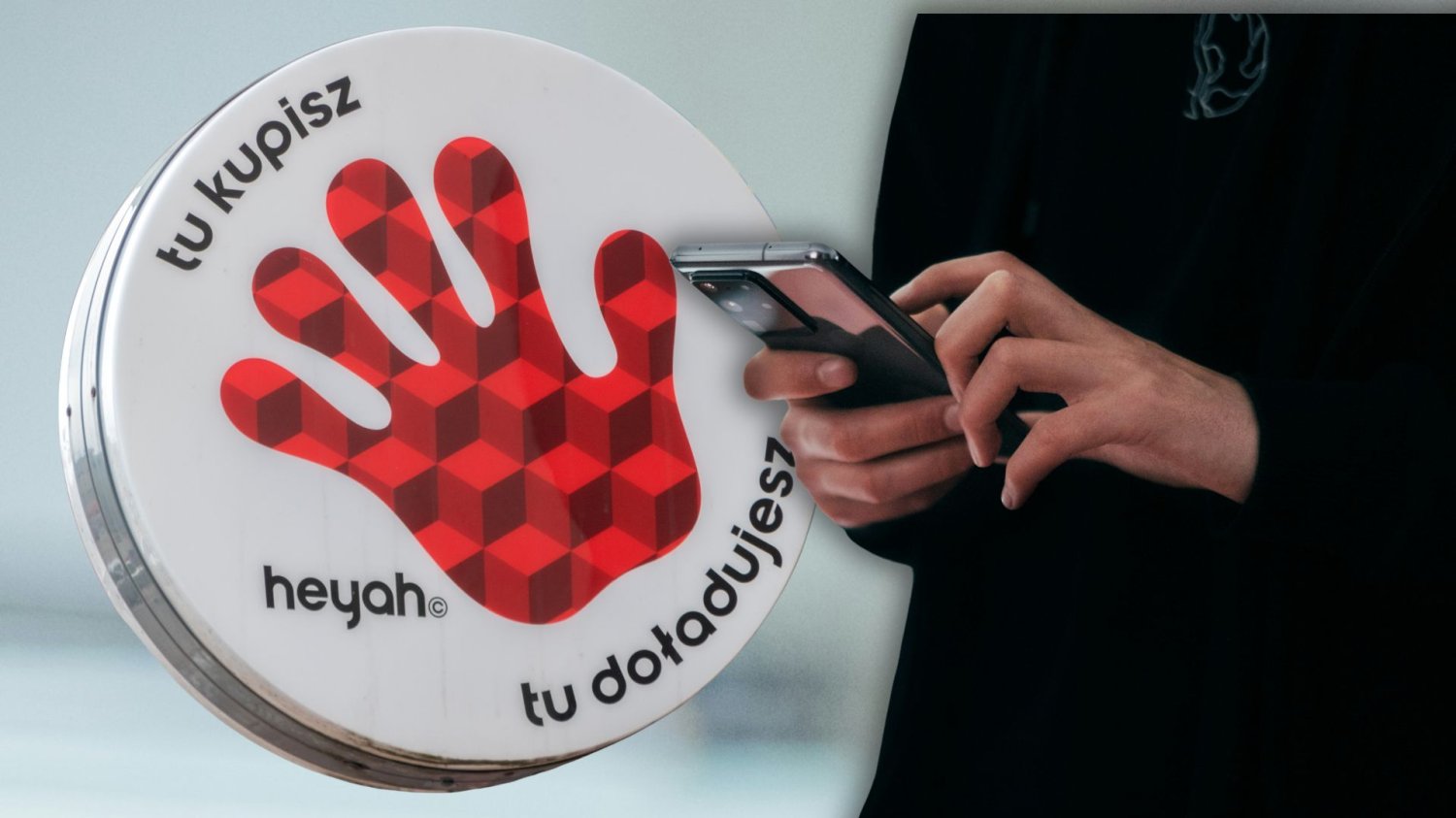 Logo marki Heyah, kobieta trzyma w ręce smartfona.