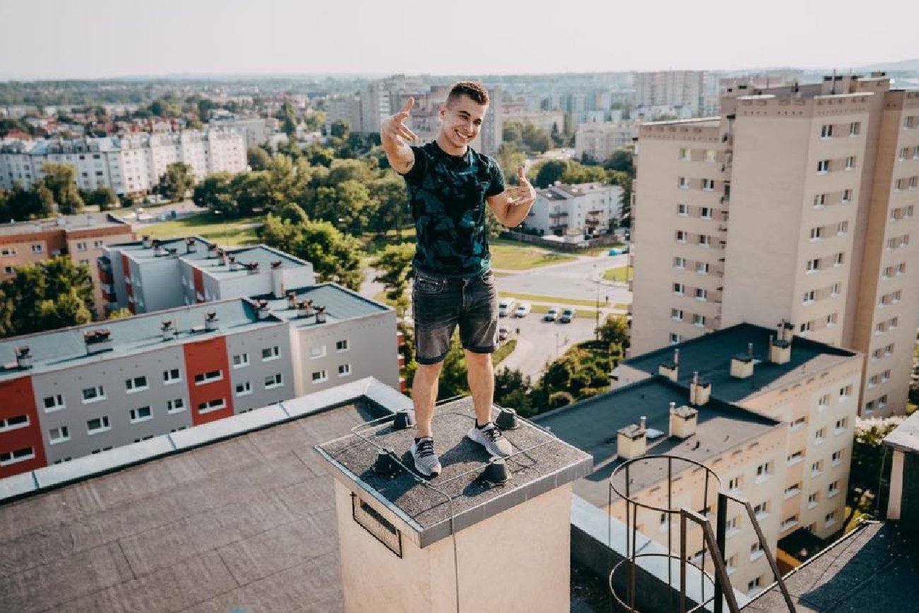 młody mężczyzna Friz na dachu starego bloku z wielkiej płyty w Polsce