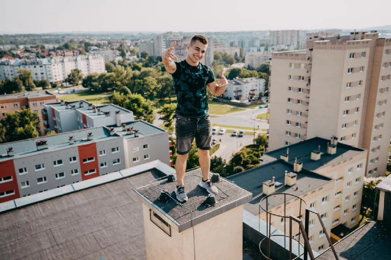 młody mężczyzna Friz na dachu starego bloku z wielkiej płyty w Polsce