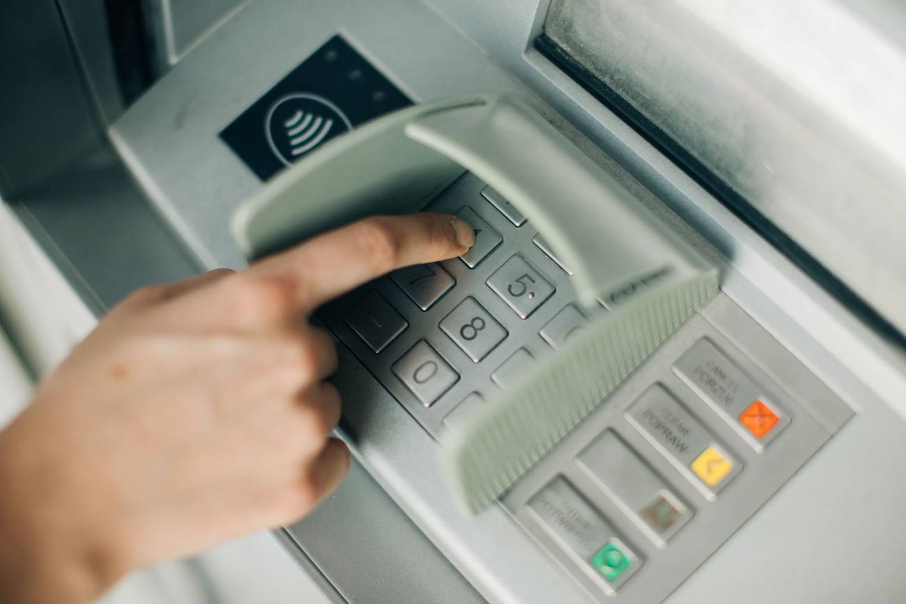 ręka pisząca po klawiaturze w bankomacie