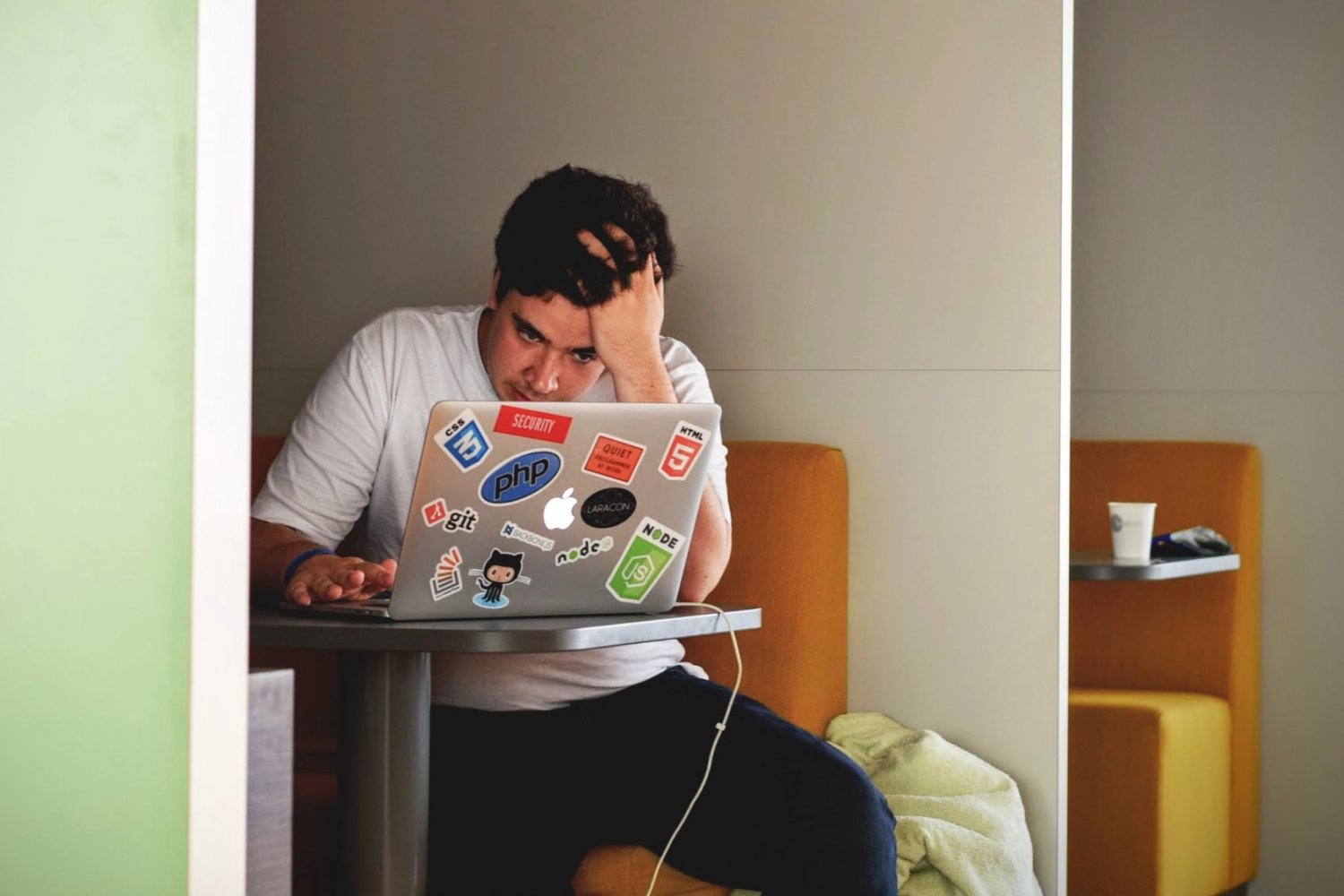 Młody mężczyzna zmartwiony patrzy w ekran laptopa