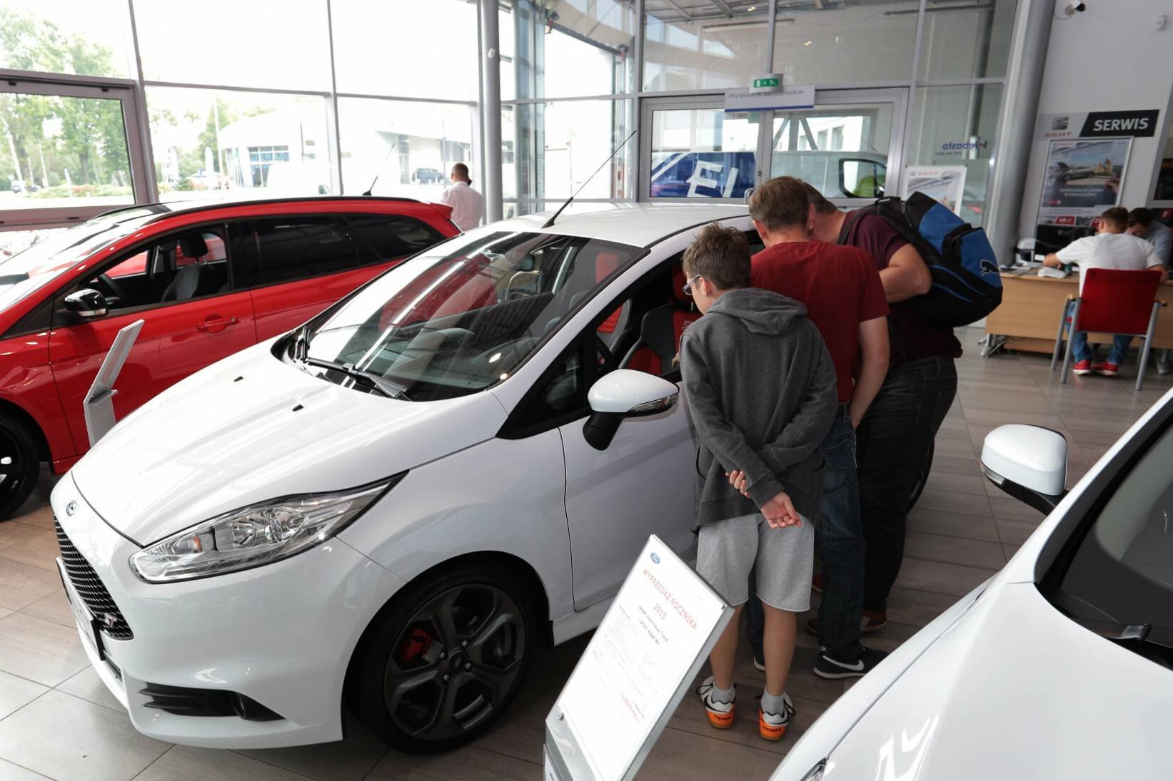 Salon samochodowy - potencjalni klienci oglądają auto