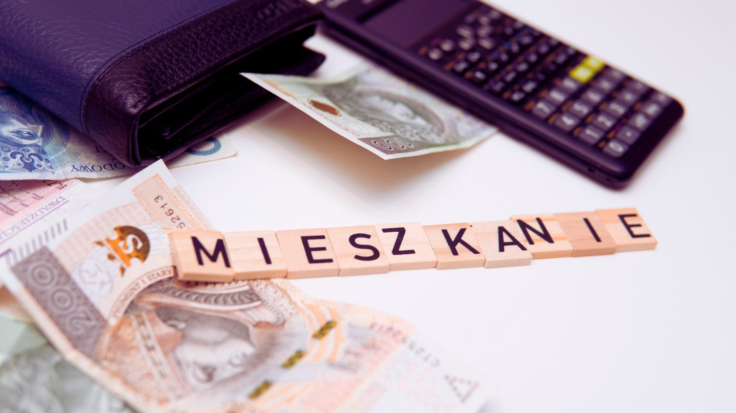 Koniec swobody wynajmu od 20 maja. Ogromne kary dla tych, którzy o to nie zadbają Napis z drewnianych klocków: Mieszkanie. W tle kalkulator, pieniądze.
