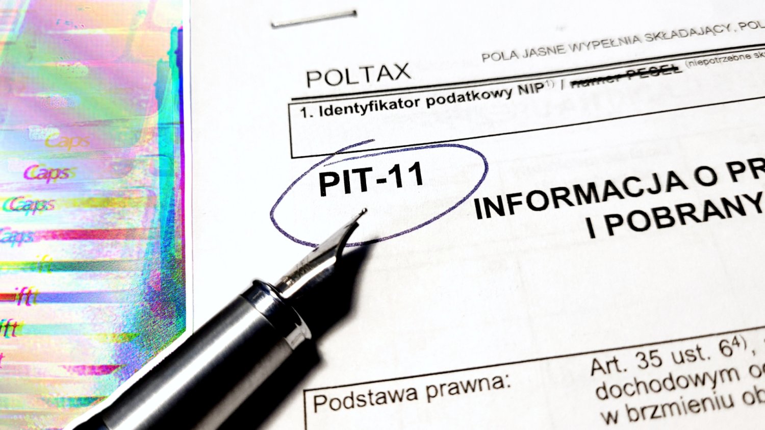 Koniec wygody wokół PIT-11. Rząd szykuje ogromne zmiany w rozliczeniach Pióro i uzupełnianie dokumentów PIT-11. W tle klawiatura komputerowa z efektami.