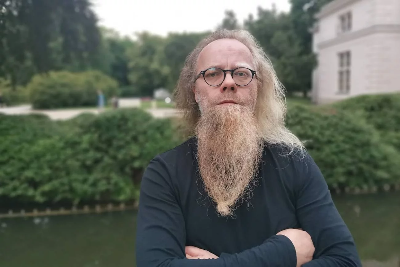 Prezes firmy deweloperskiej HRE Investments Michał Sapota. W tle Łazienki Królewskie.