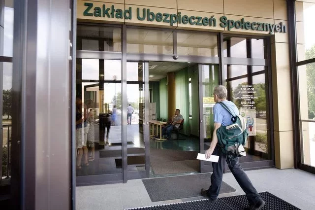 Mężczyzna z plecakiem wchodzący do Zakładu Ubezpieczeń Społecznych