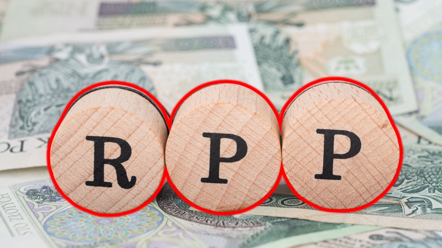 RPP zostawia stopy procentowe bez zmian. Kredytobiorcy muszą jeszcze zaczekać RPP na okrągłych drewnianych klockach. W tle pieniądze.