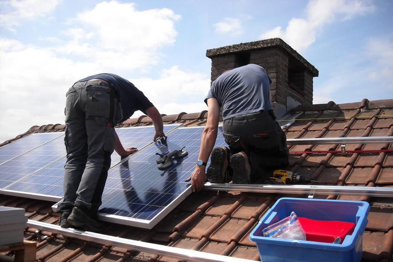 dwaj mężczyźni montujący panele fotowoltaiczne