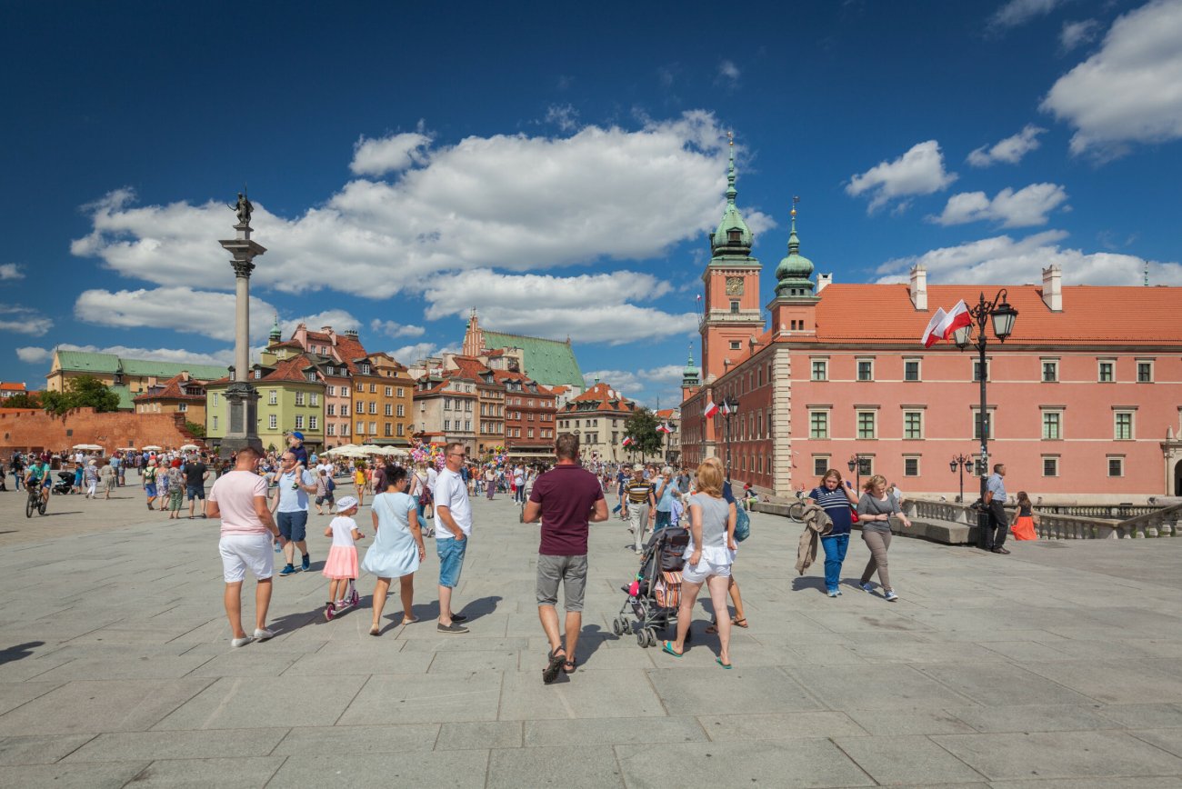 Spacerowicze przy Zamku Królewskim w Warszawie