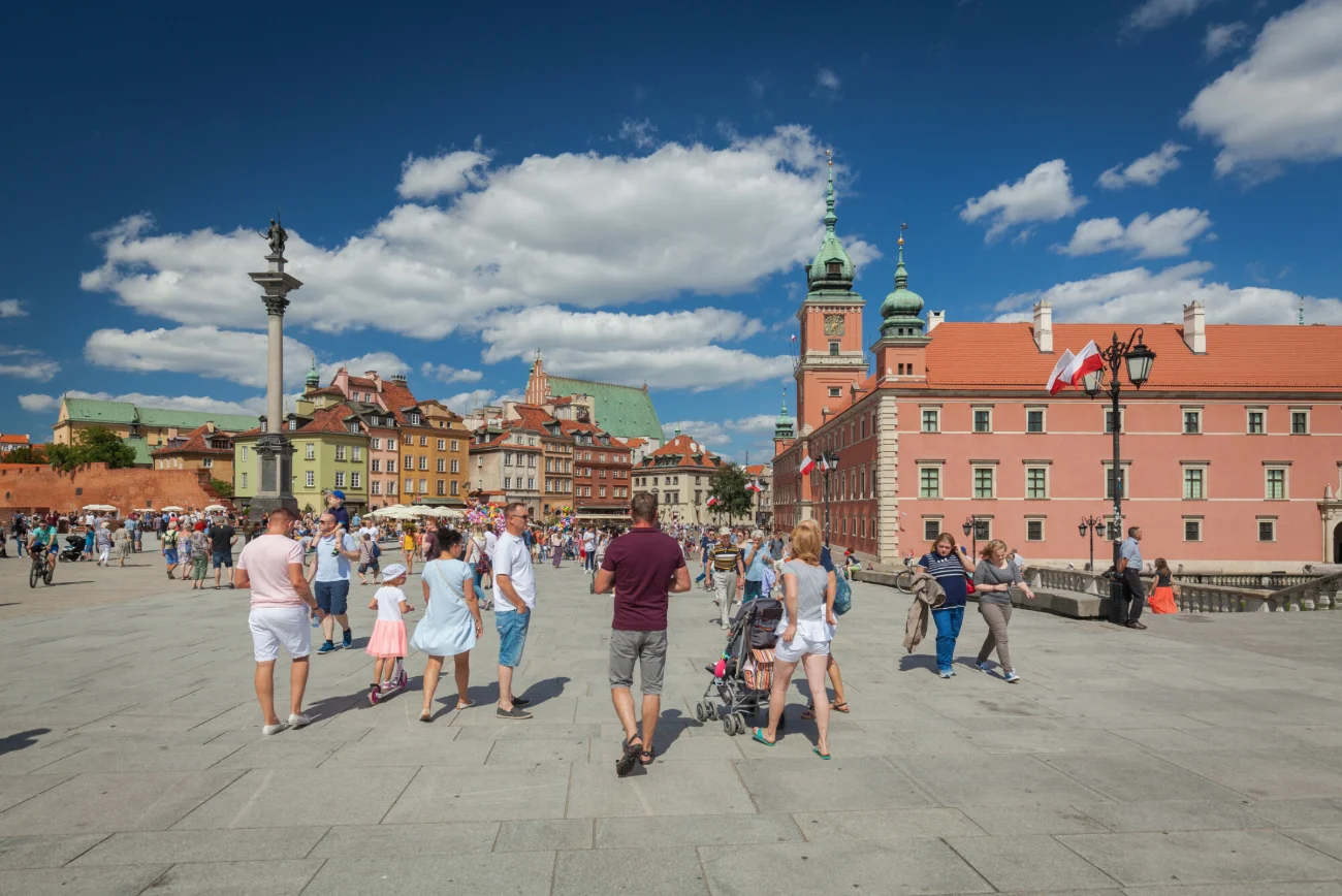 Spacerowicze przy Zamku Królewskim w Warszawie
