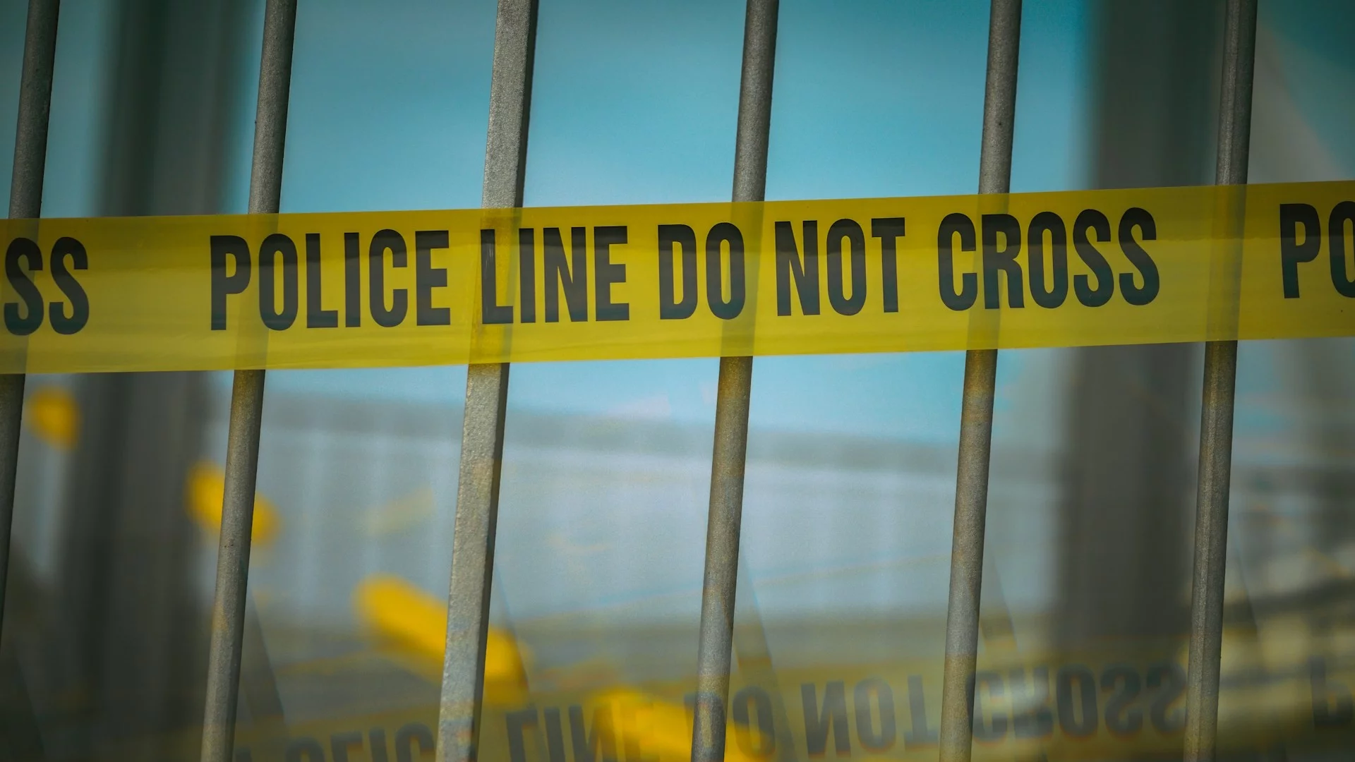 Okno za kratami, na których wisi taśma z napisem "Linia policyjna. Nie przekraczać". Są wyniki badania, które pokazują, dlaczego powstaje wrażenie, że cudzoziemcy to przestępcy.