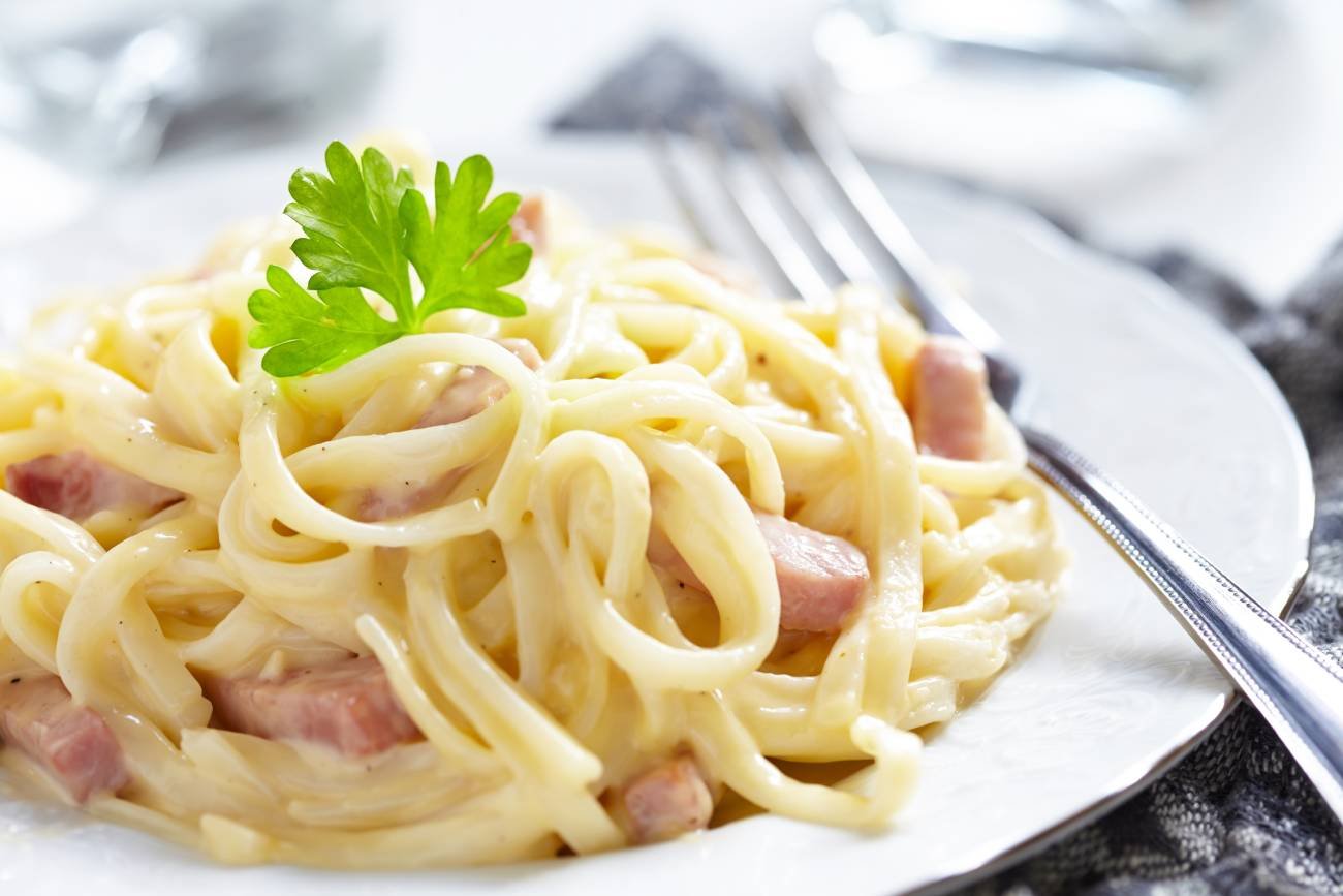 Restauracja. Spaghetti Carbonara z widelcem w zbliżeniu.