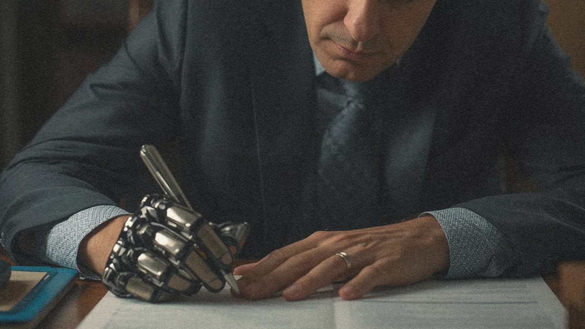 Człowiek z ręką robota pisze długopisem w zeszycie. Ponad połowa tego, co czytasz to już AI