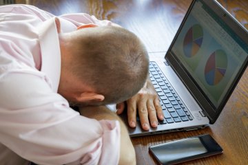 Pracownik leżący na laptopie