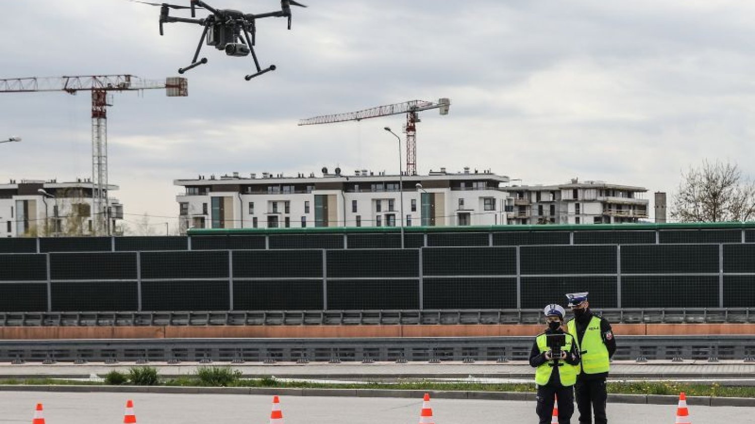 Patrol policji drogowej przy trasie S7 sterujący dronem.