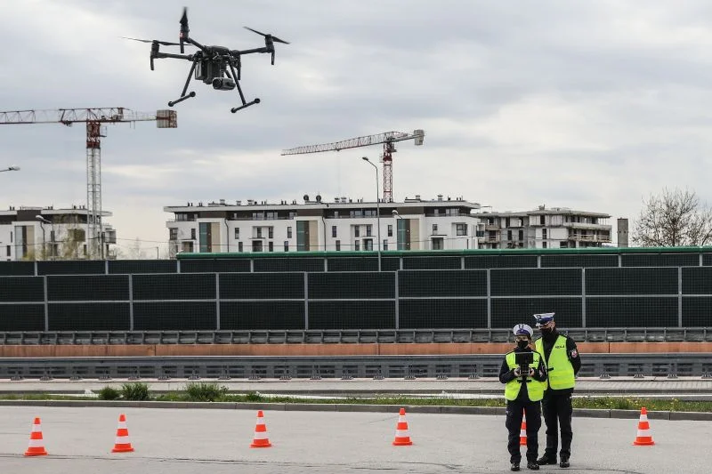Patrol policji drogowej przy trasie S7 sterujący dronem.