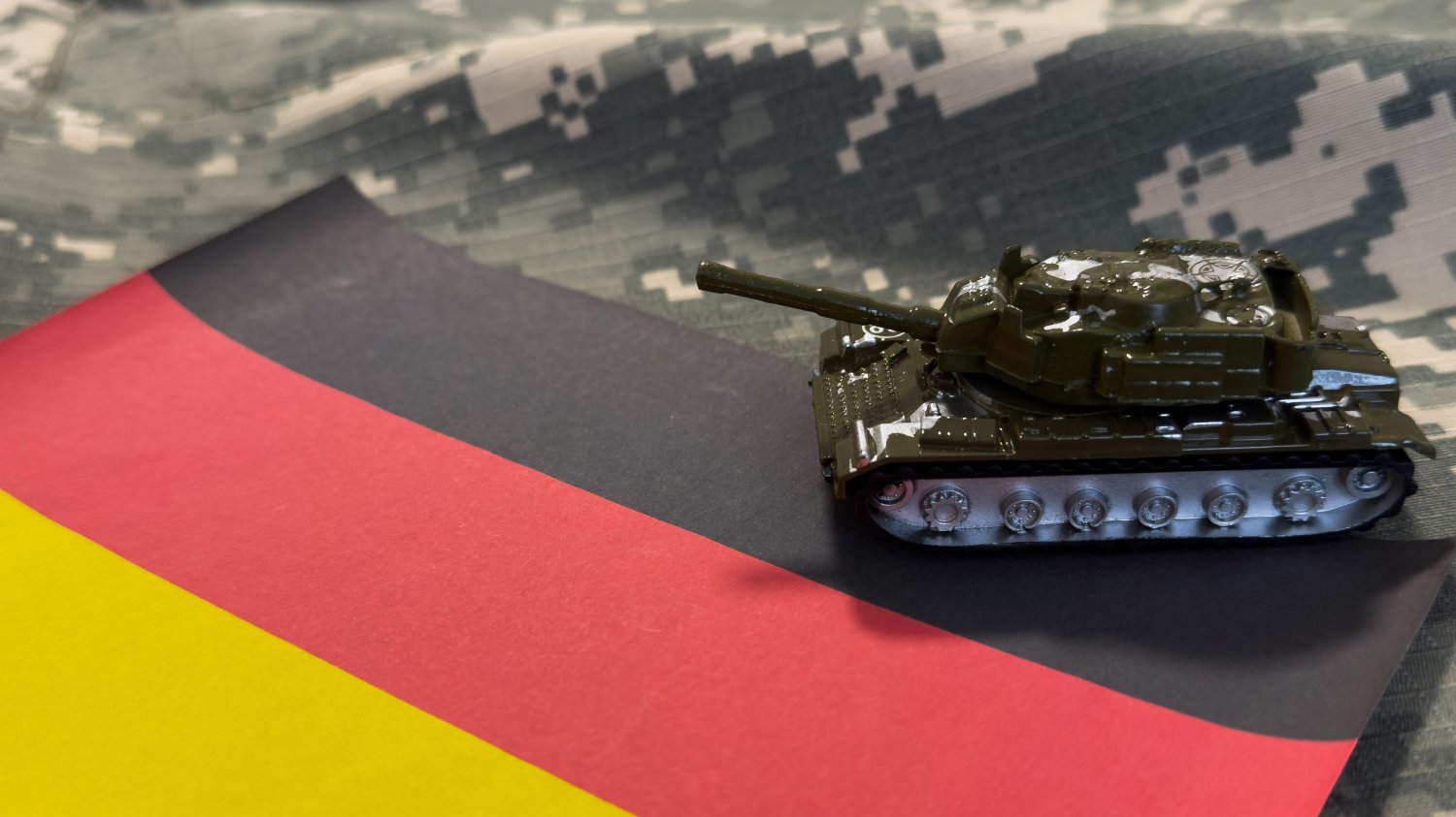 Nowe prawo w Niemczech uderza w młodych mężczyzn. Bundeswehrę zalewa krytyka. Model czołgu na fladze Niemiec. Nowe prawo w Niemczech uderza w młodych mężczyzn. Bundeswehrę zalewa krytyka.