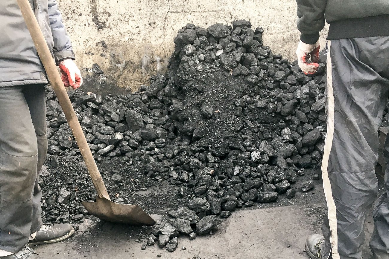 dwóch mężczyzn pracuje na składzie węgla w porze roku zima