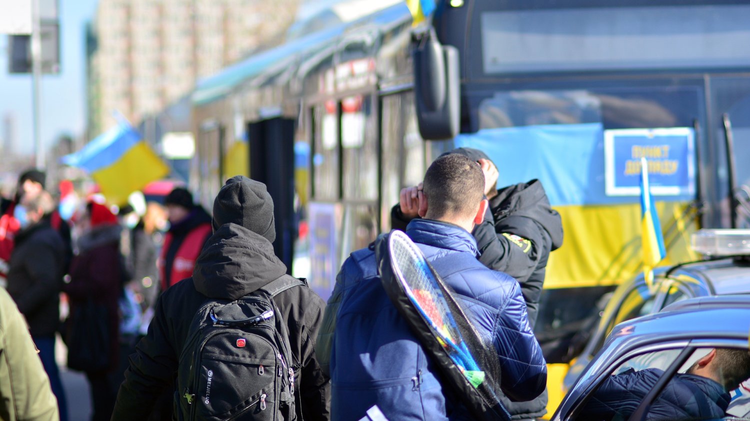 Specustawa traci moc. Ukraińcy będą traktowani jak inni cudzoziemcy Obywatele Ukrainy z flagami wysiadający z autobusu w Warszawie.