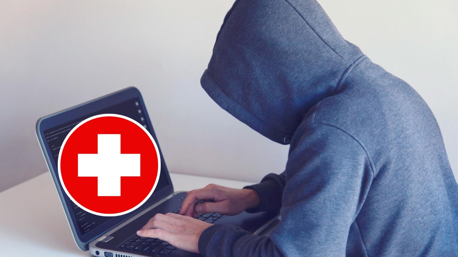 Hakerzy atakują polskie szpitale. Cyberprzestępcy żerują na pacjentach Haker z laptopem z symbolem krzyża ochrony zdrowia. Hakerzy atakują polskie szpitale. Cyberprzestępcy kradną dane pacjentów