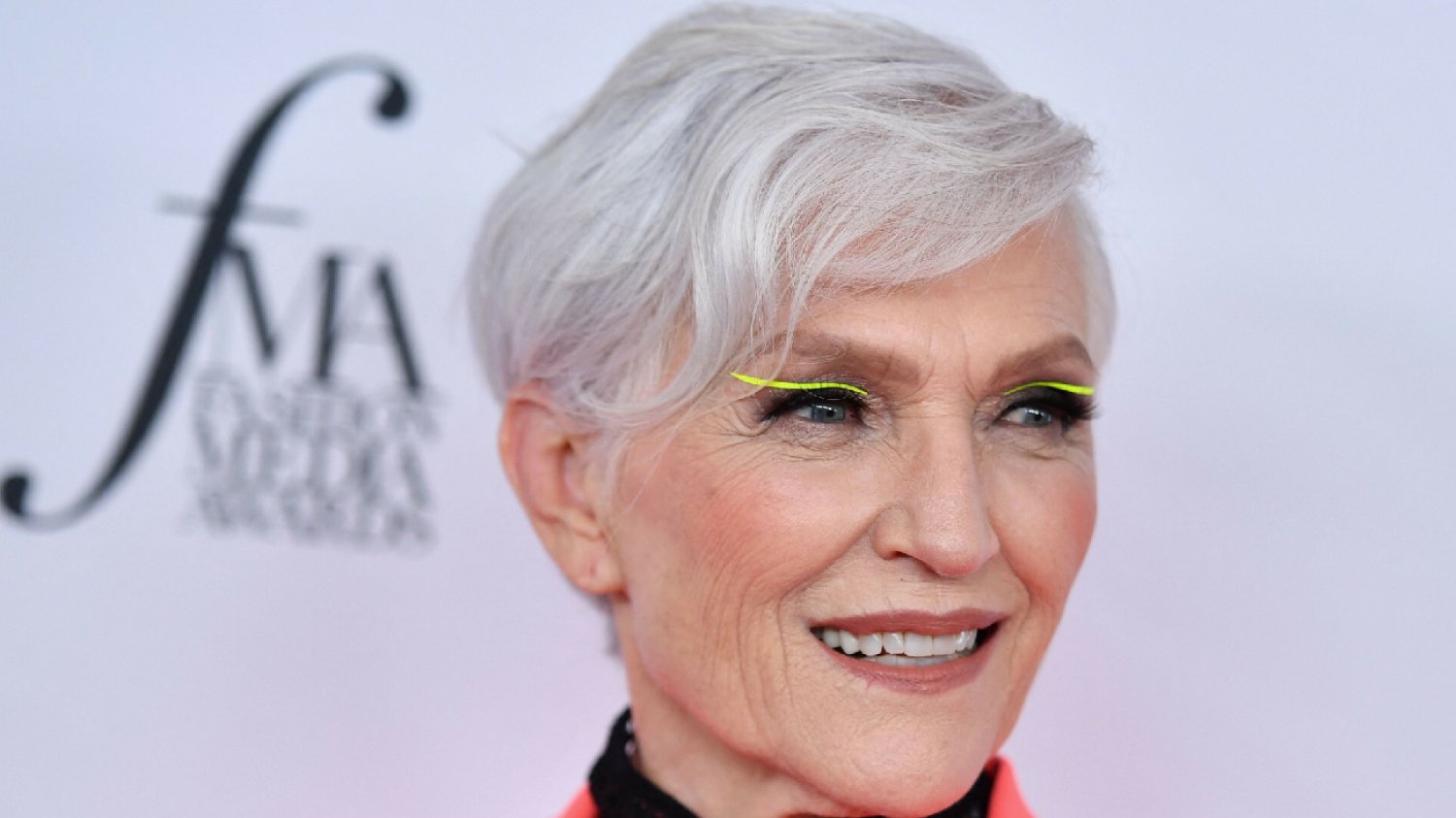 Maye Musk na ściance podczas konferencji w wyzywającym makijażu i żółtą kreską na oczach