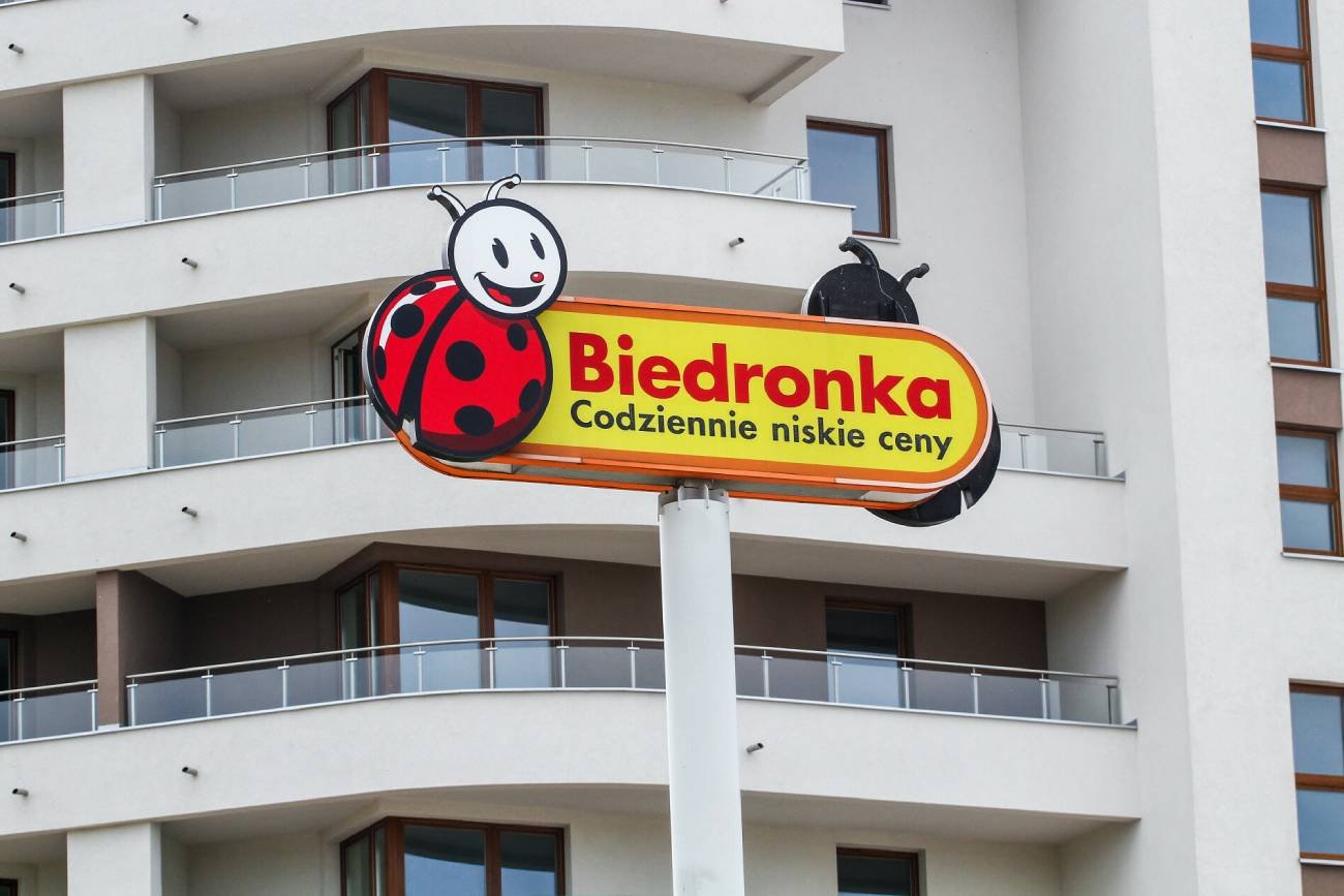 Logo Biedronki na tle mieszkań.