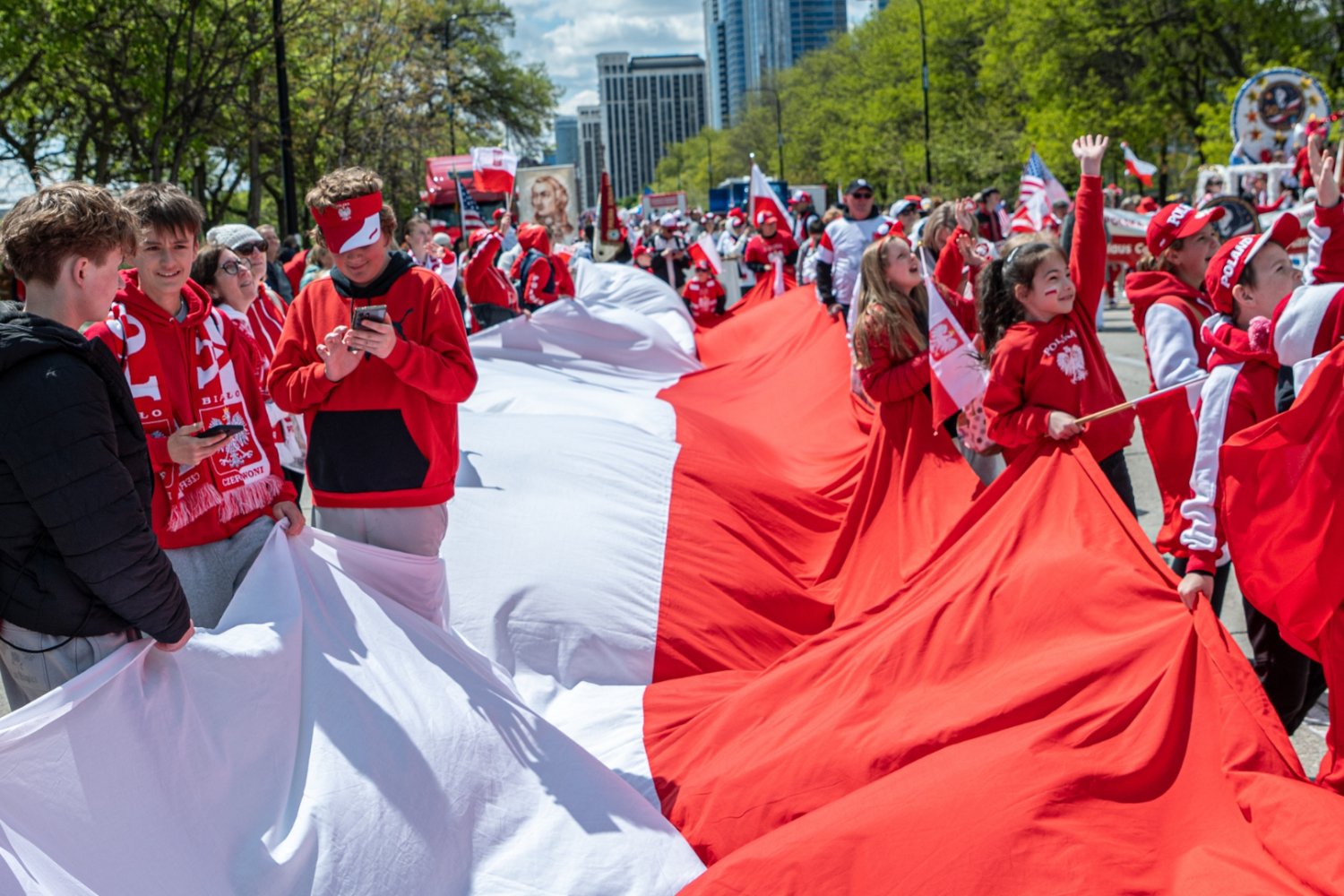 Flaga Polski trzymana przez Polaków w Chicago. Dzień Flagi Narodowej.