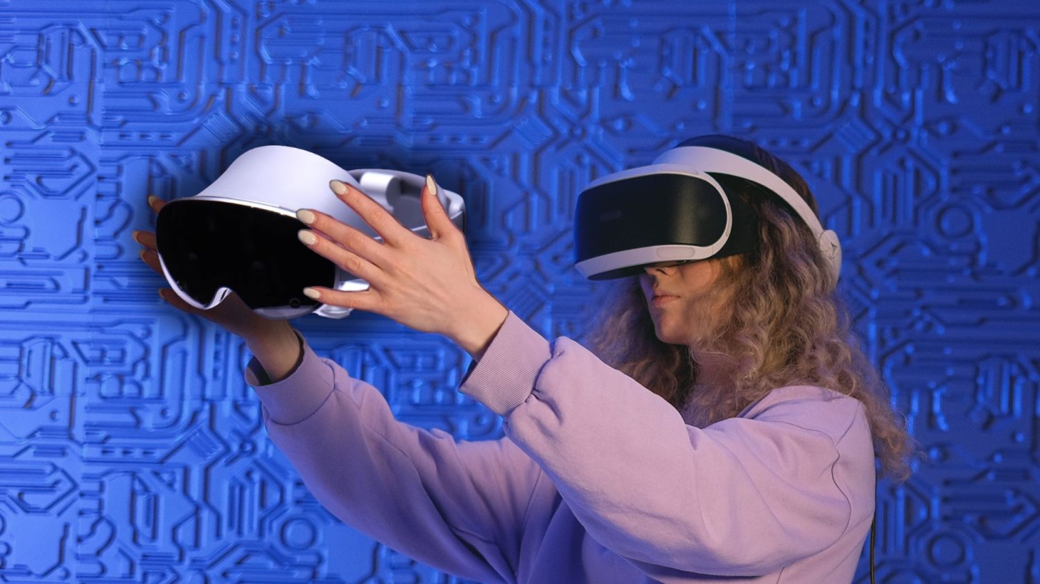 Komputery i smartfony to już przeżytek. Google z Samsungiem szykują coś nowego Kobieta w starych goglach VR trzymająca nowy sprzęt Samsunga. Premiera gogli XR o 4 rano w środę czasu polskiego.