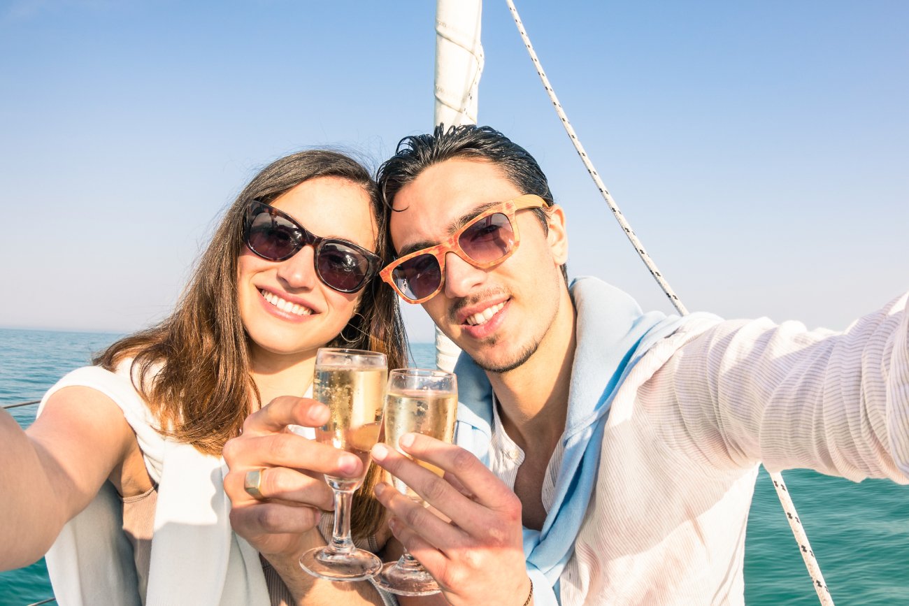 Młoda bogata para z kieliszkami szampana w dłoniach.