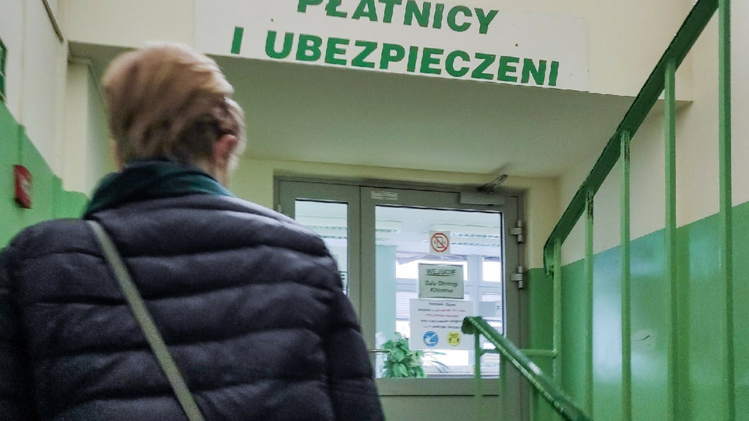 kobieta idzie schodami w górę po placówce ZUS