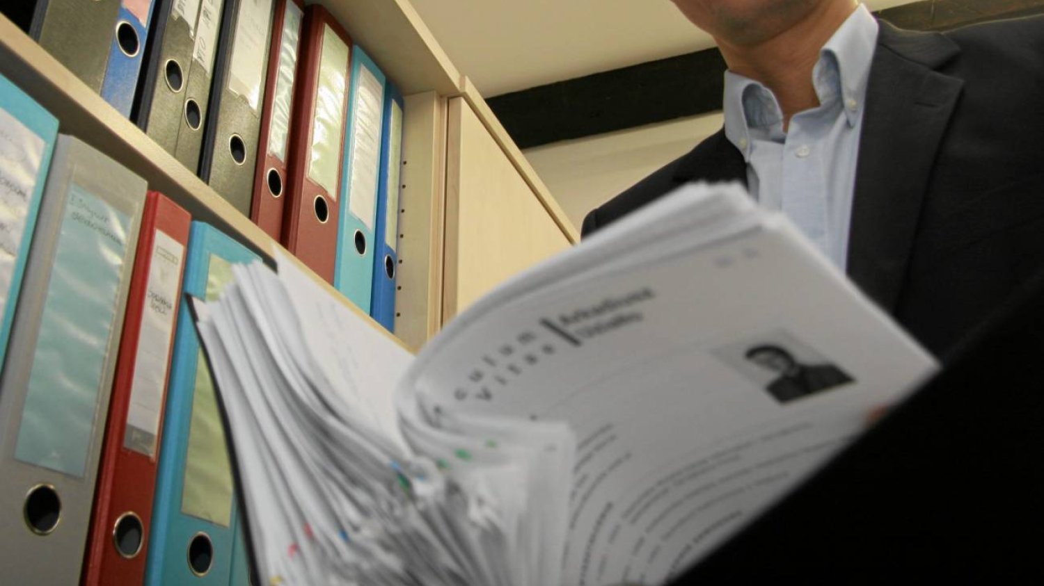 Mężczyzna sprawdzający dokumentacje księgową firm.