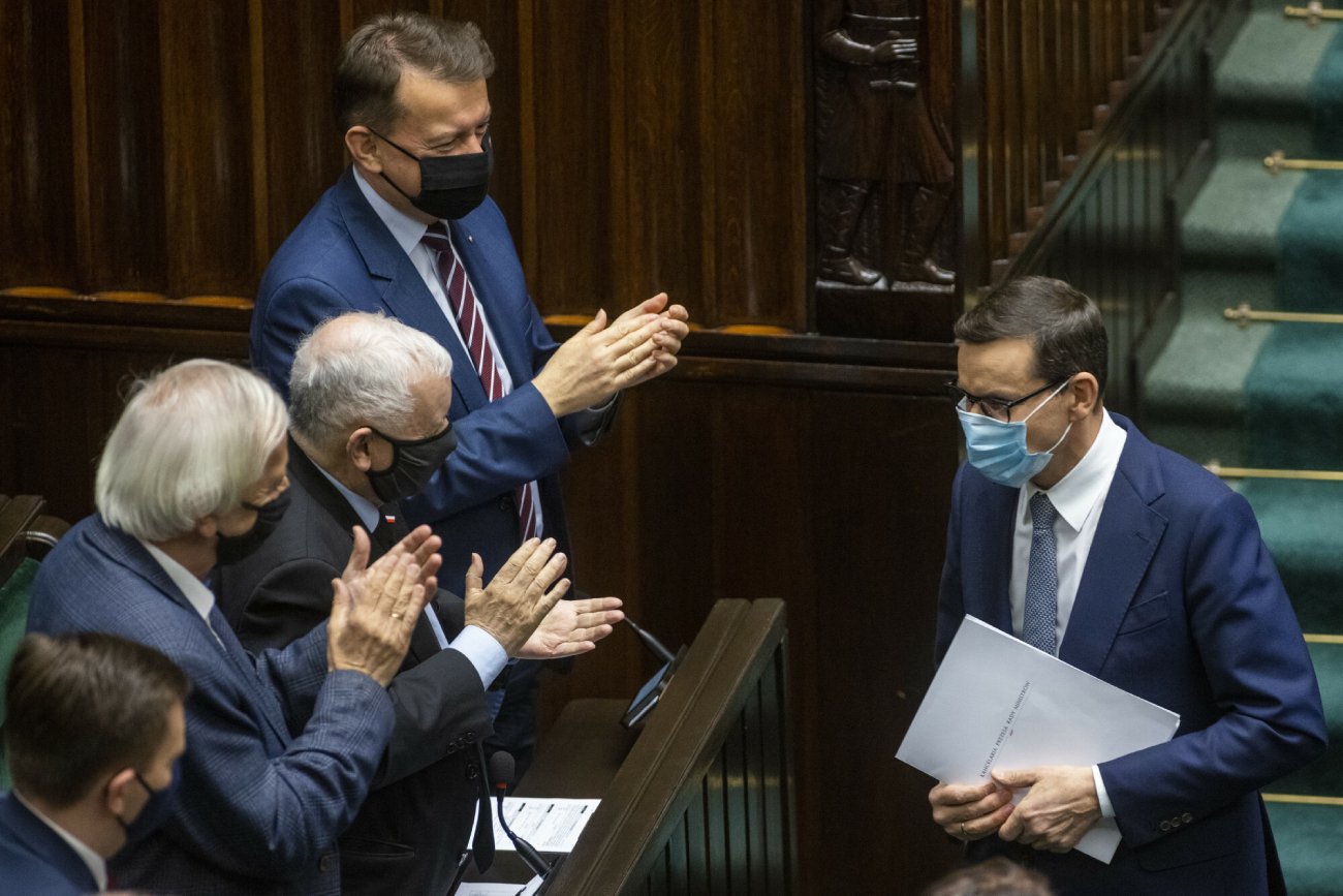 politycy PiS w sejmie podczas posiedzenia sejmu klaszczą na Morawieckiego, który idzie usiąść w maseczce