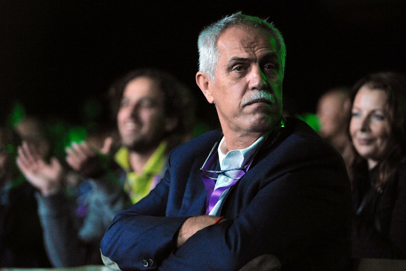 Zygmunt Solorz siedzi w tłumie ludzi