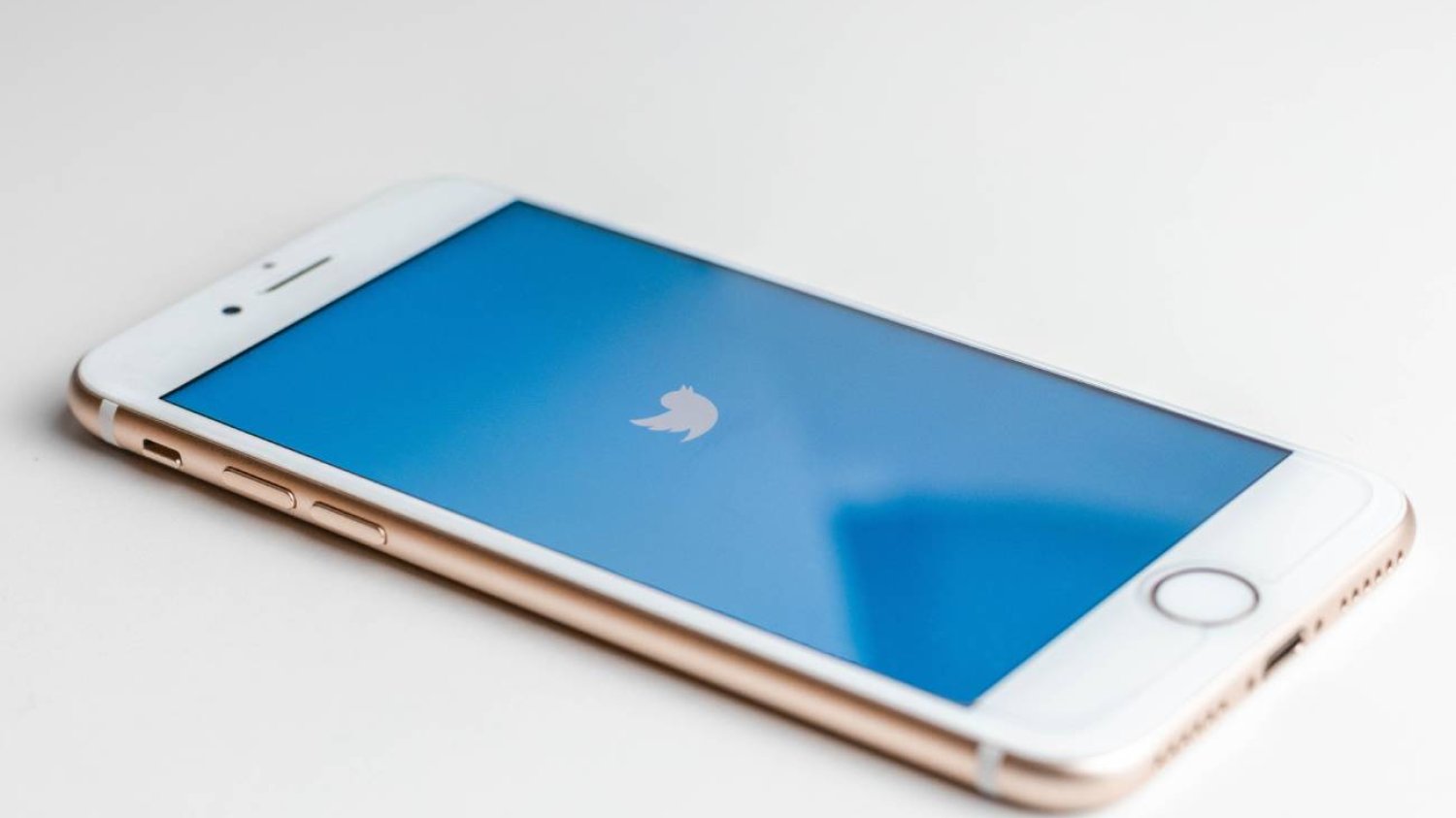 Smartfon na stole. Na ekranie aplikacja Twitter.