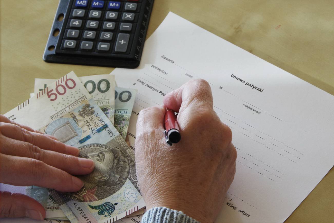 Senior podpisujący umowę pożyczki.