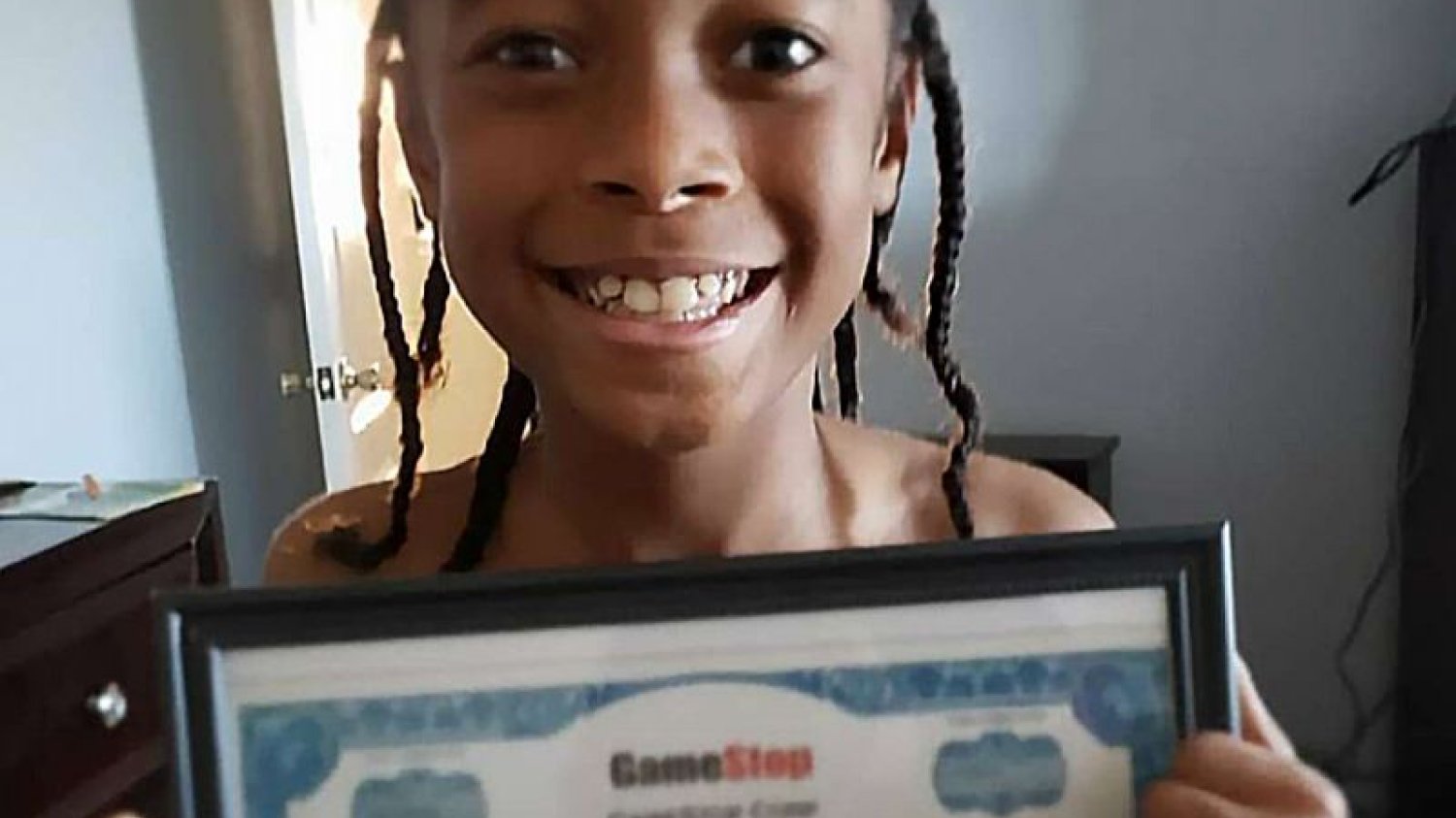 Jaydyn Carr z certyfikatem posiadania akcji Gamestop.