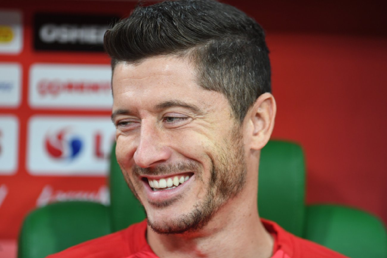 uśmiechnięty Robert Lewandowski patrzy w bok na konferencji prasowej w sprawie piłki nożnej