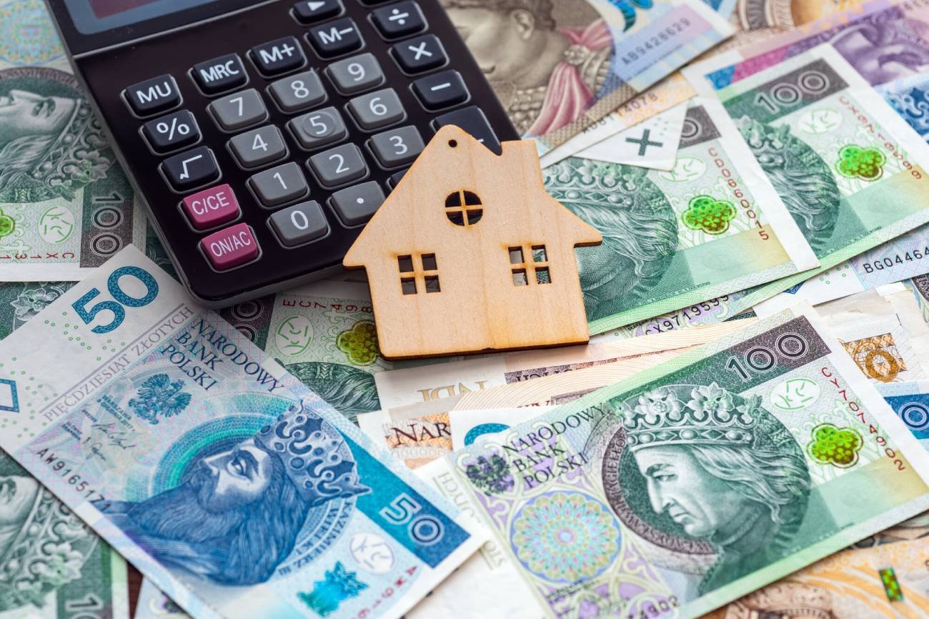 Kalkulator i wycinka domu na pieniądzach.