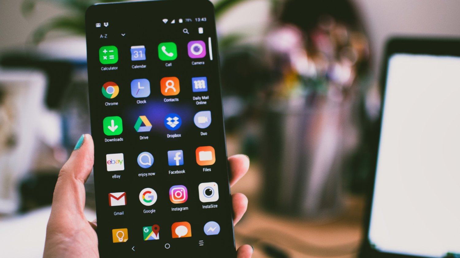 Aplikacje na ekranie smartfonu z systemem Android, trzymanym w ręce przez użytkownika.