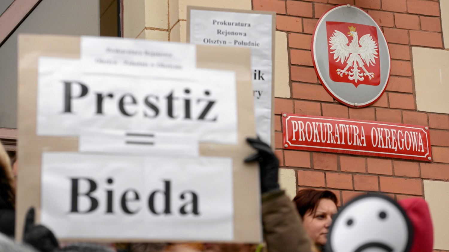 Protest pracowników prokuratury, na pierwszym planie baner z napisem "prestiż = bieda"