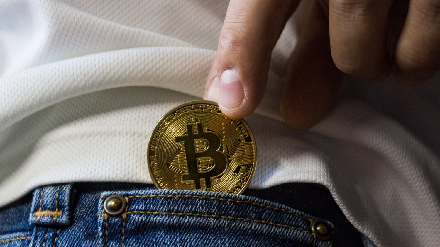 Bitcoin chowany do kieszeni. Zdjęcie symboliczne.