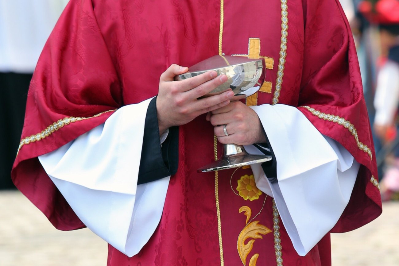 Ksiądz rozdający komunię świętą.