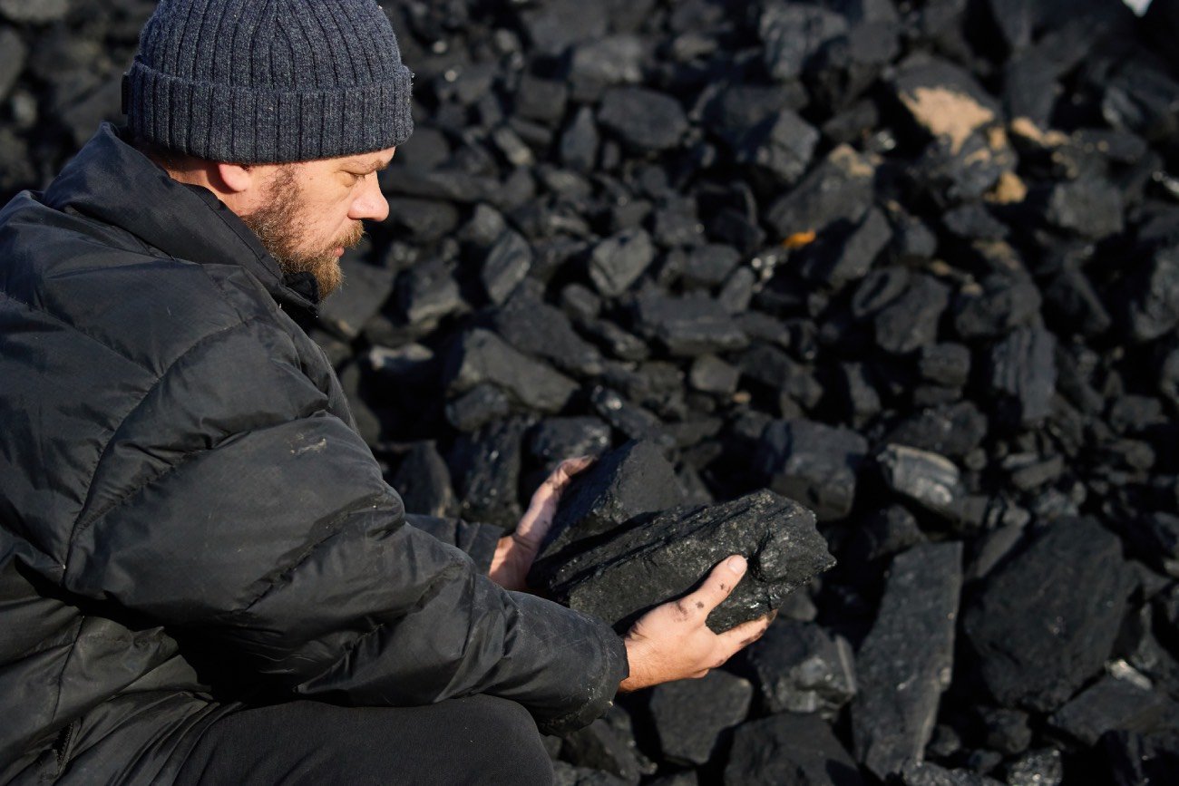 mężczyzna z grudką węgla