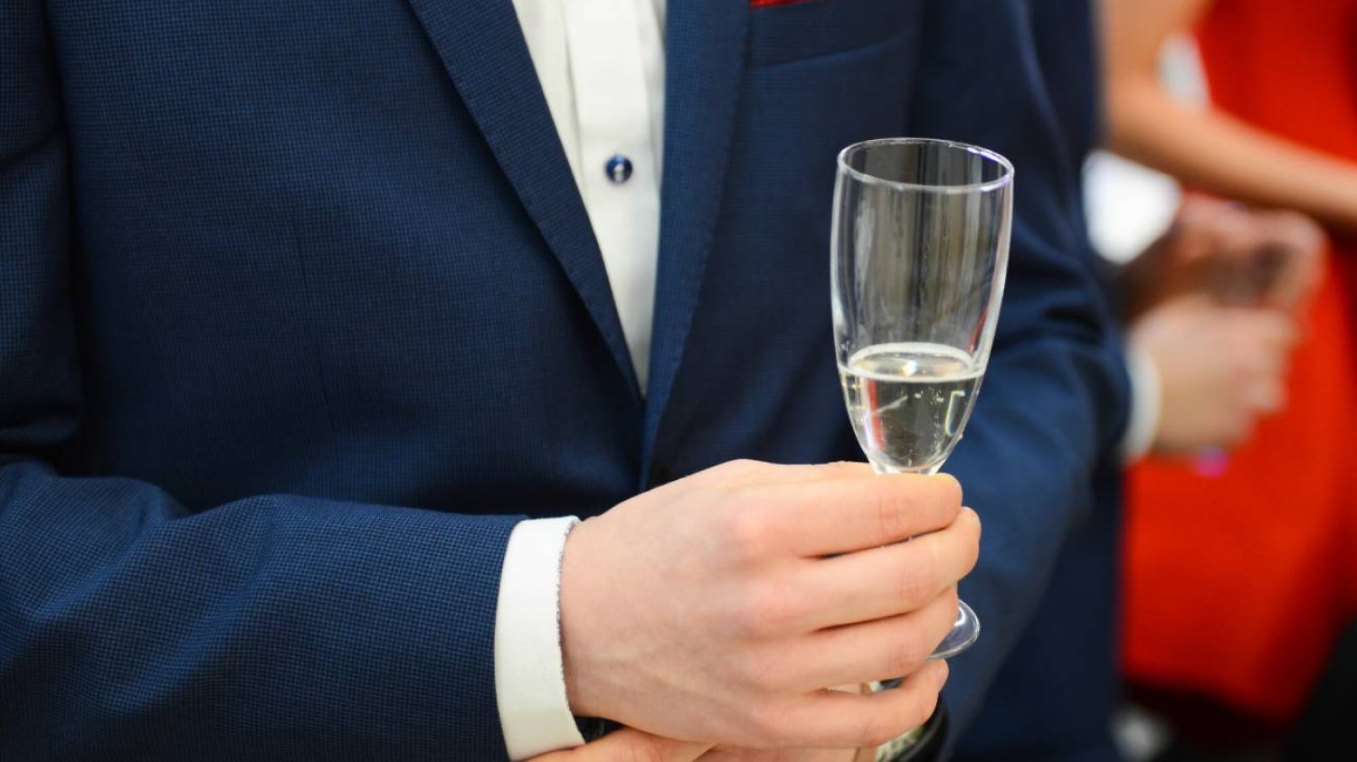 Mężczyzna w garniturze pije alkohol