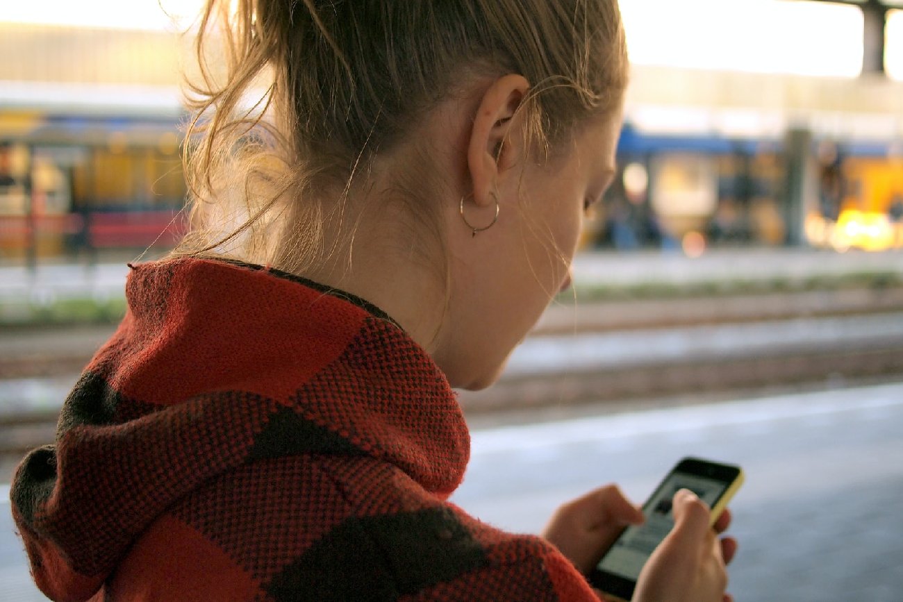 Dziewczyna trzymająca w dłoniach telefon