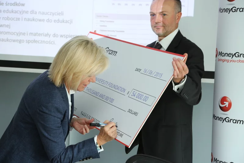 Pam Patsley z Zarządu MoneyGram podpisuje grant, który ma zostać przekazany krakowskiej Fundacji.